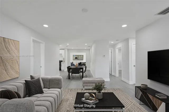 a living room with furniture a rug and a flat screen tv