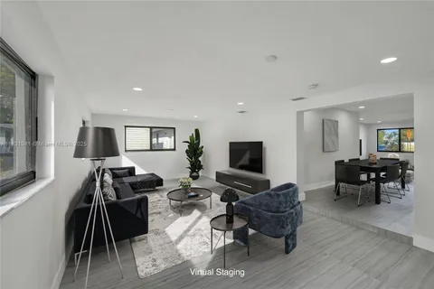 a living room with furniture a wooden floor and a flat screen tv