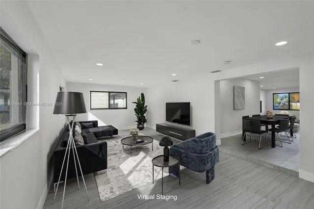 a living room with furniture a wooden floor and a flat screen tv