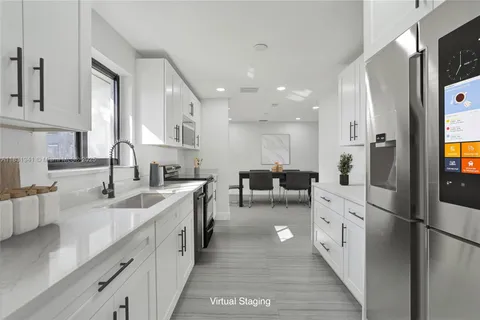 a kitchen with white cabinets and refrigerator