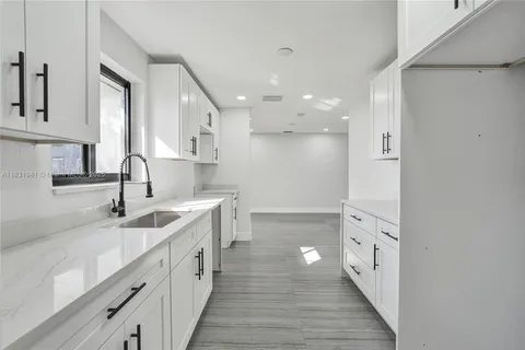 a kitchen with granite countertop a sink and cabinets