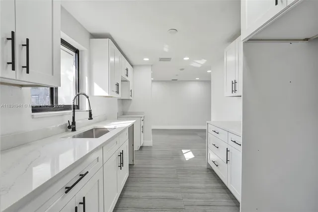 a kitchen with granite countertop a sink and cabinets