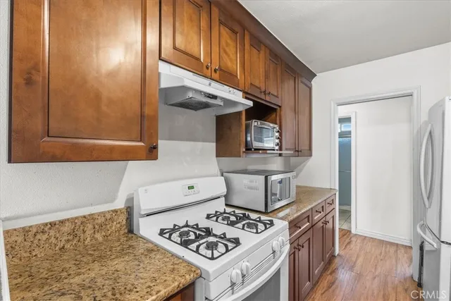 a kitchen with stainless steel appliances granite countertop a stove and a refrigerator