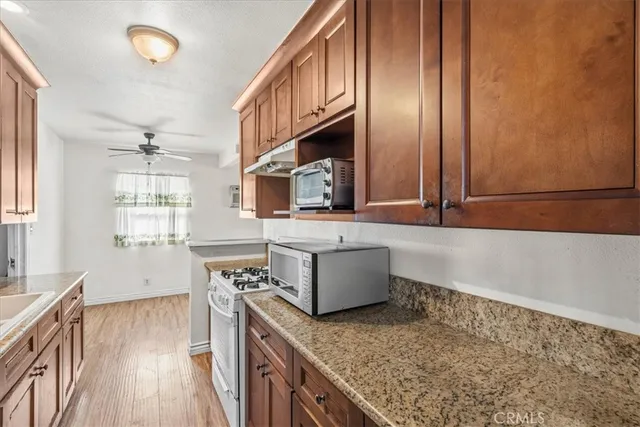 a kitchen with stainless steel appliances granite countertop a stove a sink and a microwave