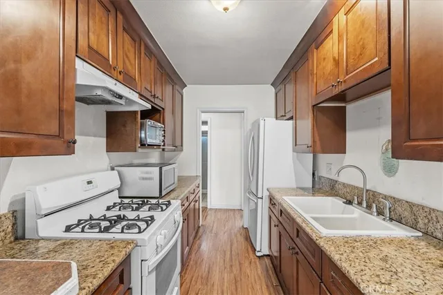 a kitchen with stainless steel appliances granite countertop a sink stove and cabinets