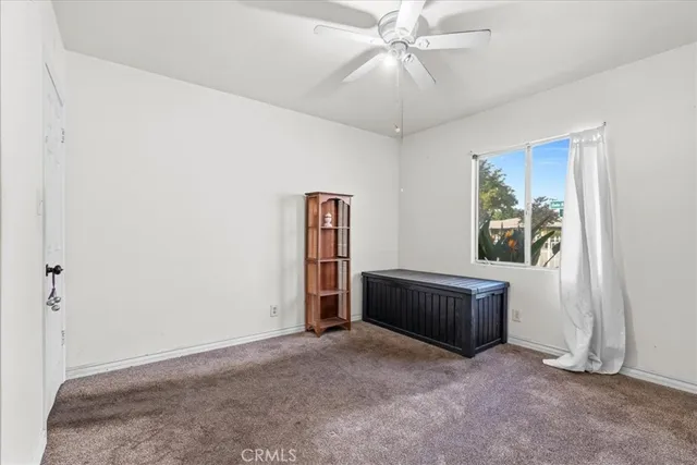 an empty room with fan and windows