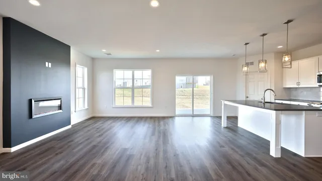 a large kitchen with a wooden floor and large windows