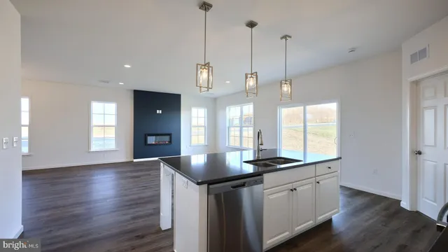 a kitchen with granite countertop a sink a center island a counter space and a window