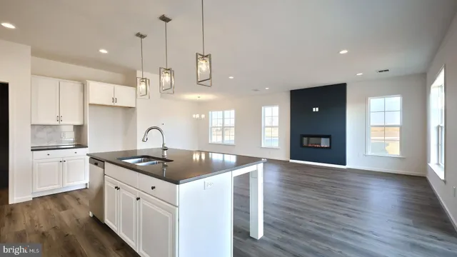 a kitchen with stainless steel appliances granite countertop a sink a stove and a wooden floors