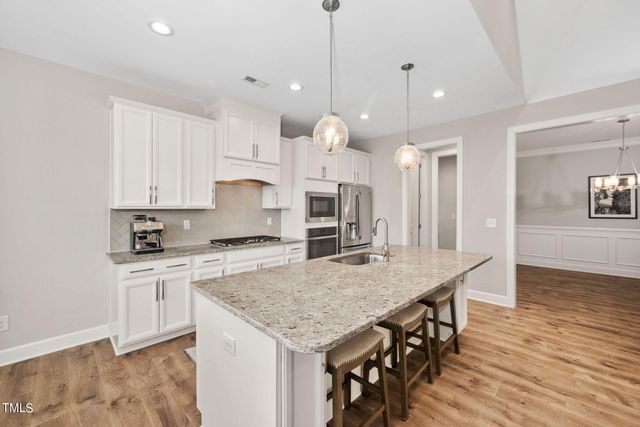 a kitchen with granite countertop white cabinets and stainless steel appliances