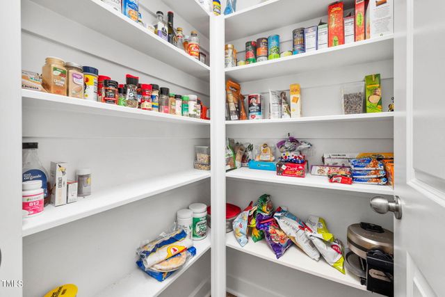 a utility room with lots of clutter and refrigerator