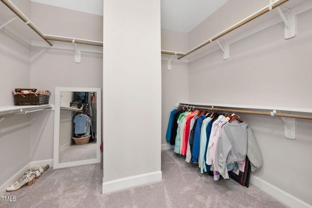 a view of walk in closet with clothes and shoes