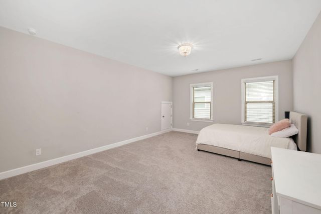 a spacious bedroom with a bed and window