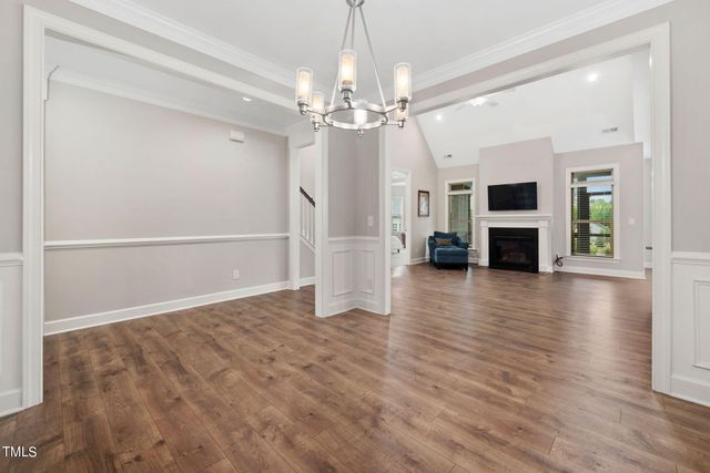 a view of a livingroom with wooden floor a ceiling fan and kitchen space window