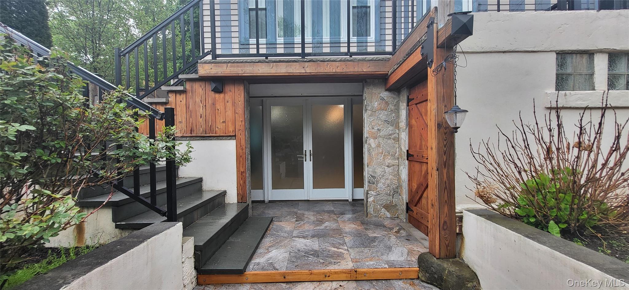 10 Marlorville Road Wappingers Falls, NY 12590 - Photo 2 of 22 Stone tile patio leading to frosted glass double entry doors, complemented by a stone facade and wood accents