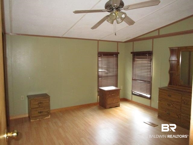20705 Greek Cemetery Road Robertsdale, AL 36567 - Photo 11 of 25 Unfurnished bedroom with light wood-style flooring, vaulted ceiling, ceiling fan, and ornamental molding