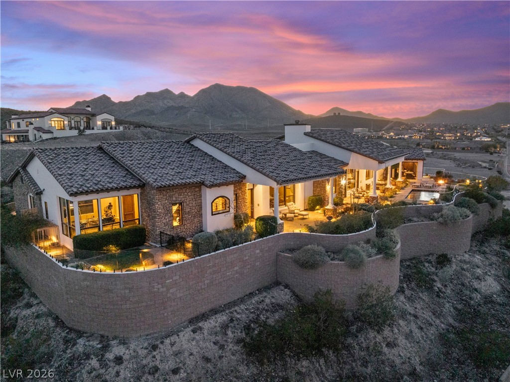 1123 Christian Road Henderson, NV 89002 - Photo 2 of 94 An exquisite desert estate, presenting a majestic home with mountain views under a vibrant sunset.