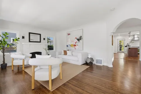 a kitchen with kitchen island white cabinets stainless steel appliances and wooden floor