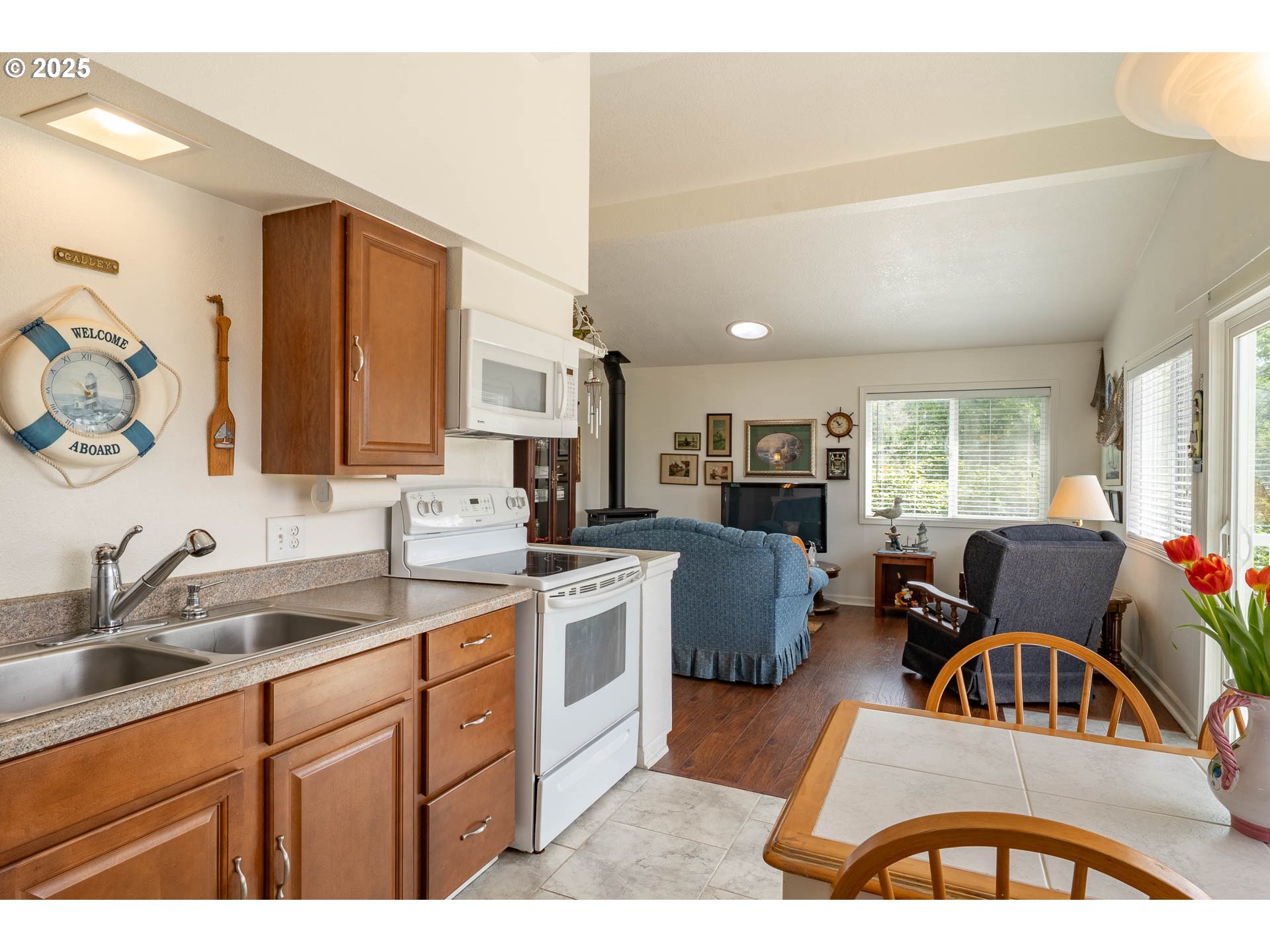 5305 Northeast 49th Street Neotsu, OR 97364 - Photo 15 of 32 a kitchen with stainless steel appliances a sink a stove a refrigerator cabinets and living room view