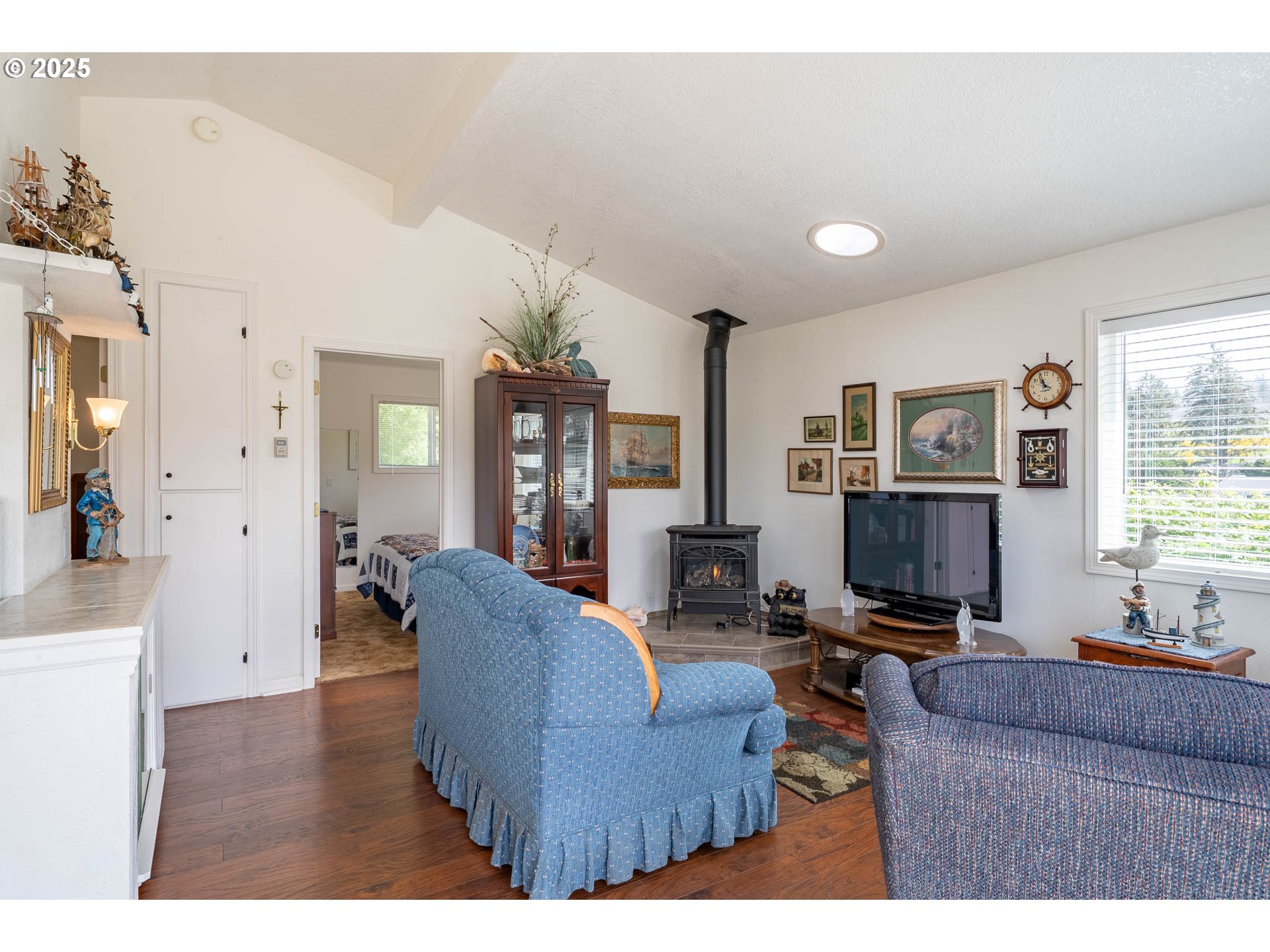5305 Northeast 49th Street Neotsu, OR 97364 - Photo 18 of 32 a living room with furniture a large window and a flat screen tv