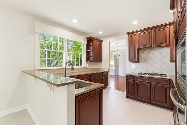 a kitchen with stainless steel appliances granite countertop a sink and a stove