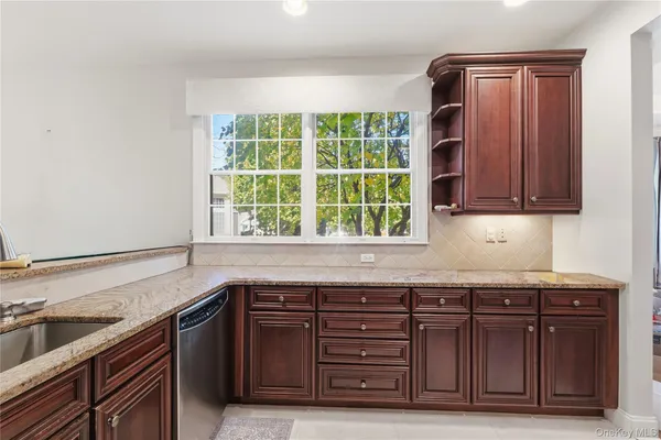 a kitchen with granite countertop a sink cabinets and a wooden floor