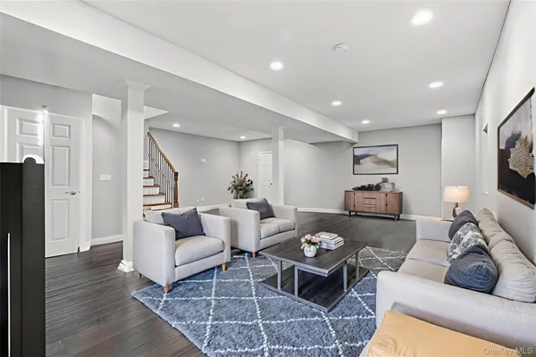 a view of an empty room with wooden floor and stairs