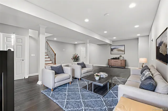 a view of an empty room with wooden floor and stairs