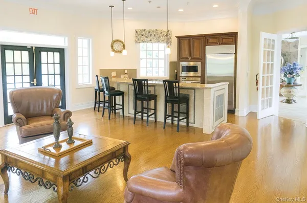 a kitchen with a stove a sink and living room view