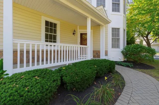a view of a house with a small yard and flower plants