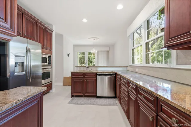 a large kitchen with stainless steel appliances granite countertop a stove and a sink