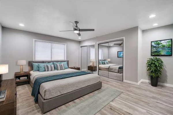 a spacious bedroom with a large bed and a chandelier