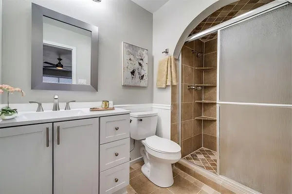 a bathroom with a toilet sink vanity and mirror