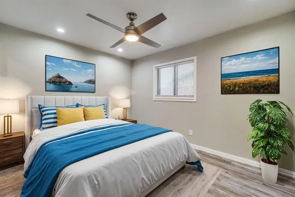 a bedroom with a large bed and a chandelier