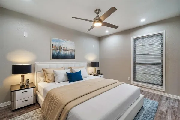 a bedroom with a large bed and a chandelier