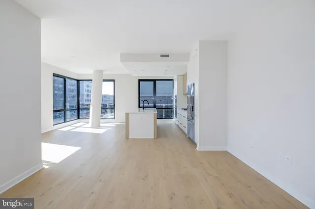 a view of a big room with wooden floor and a kitchen