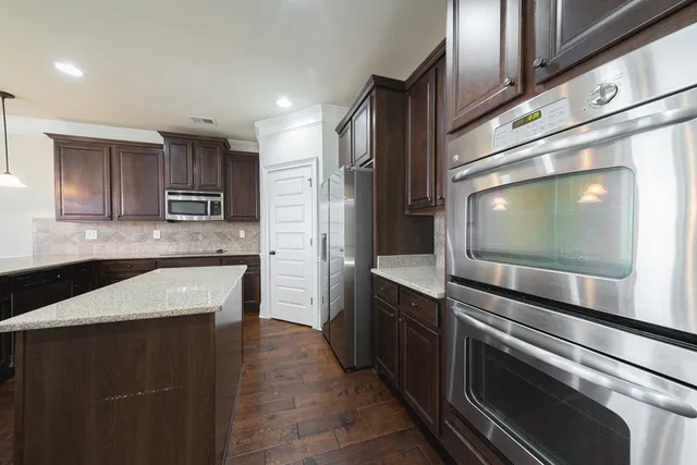 a kitchen with stainless steel appliances granite countertop a sink and a stove top oven