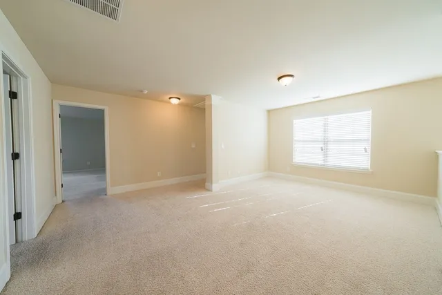 a view of empty room with windows and ceiling fan