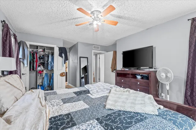 a bed room with a bed a television and cabinets