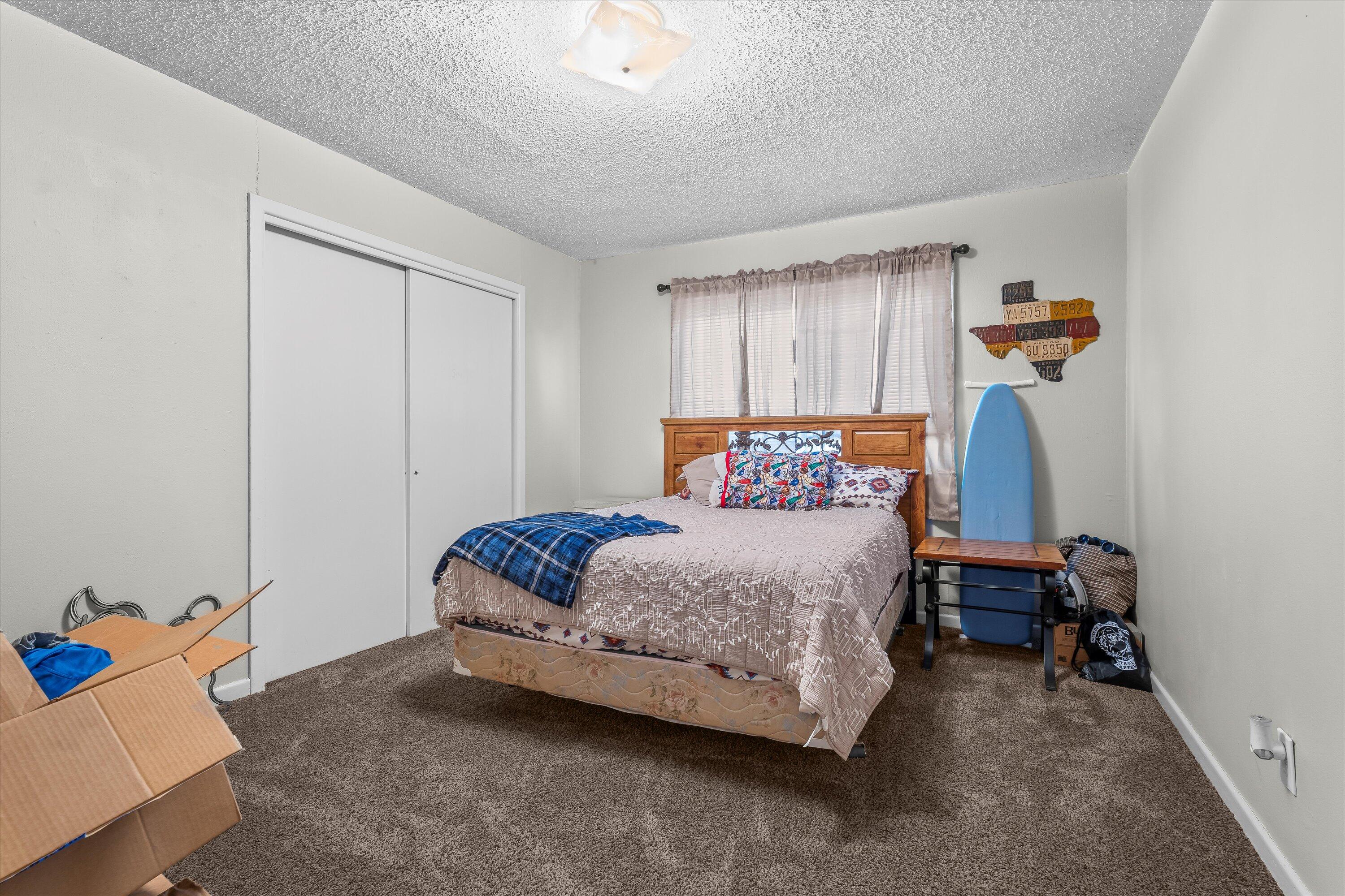 102 3rd Street Plains, TX 79355 - Photo 21 of 27 a bedroom with a bed and wooden floor