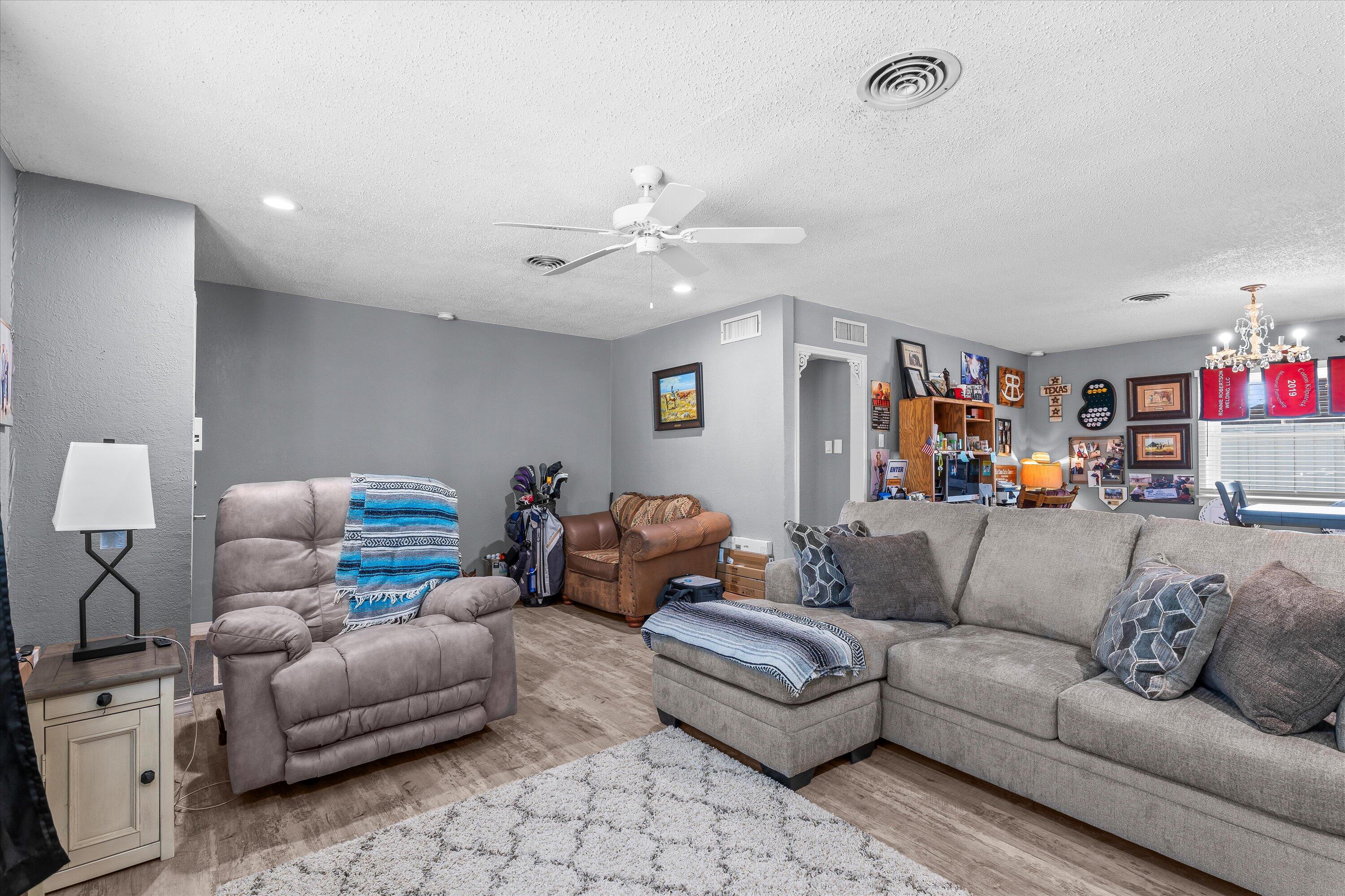 102 3rd Street Plains, TX 79355 - Photo 6 of 27 a living room with furniture and a chandelier