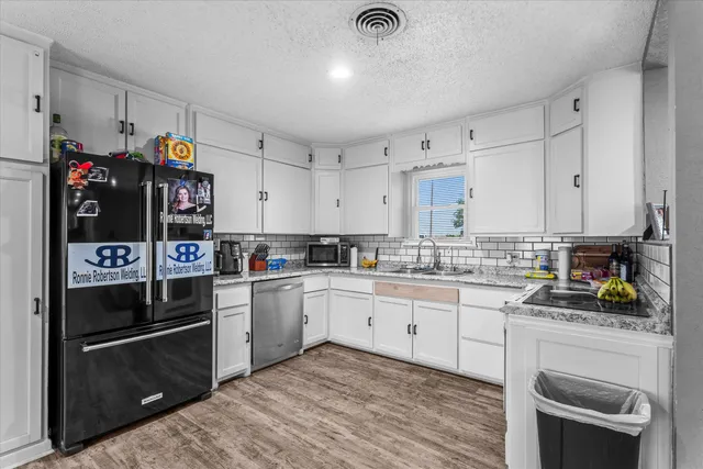 a kitchen with stainless steel appliances granite countertop a refrigerator and a stove top oven