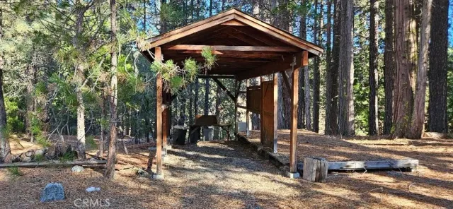 a view of a house with a tree and wooden fence