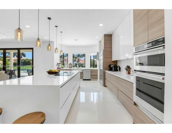 a large white kitchen with stainless steel appliances