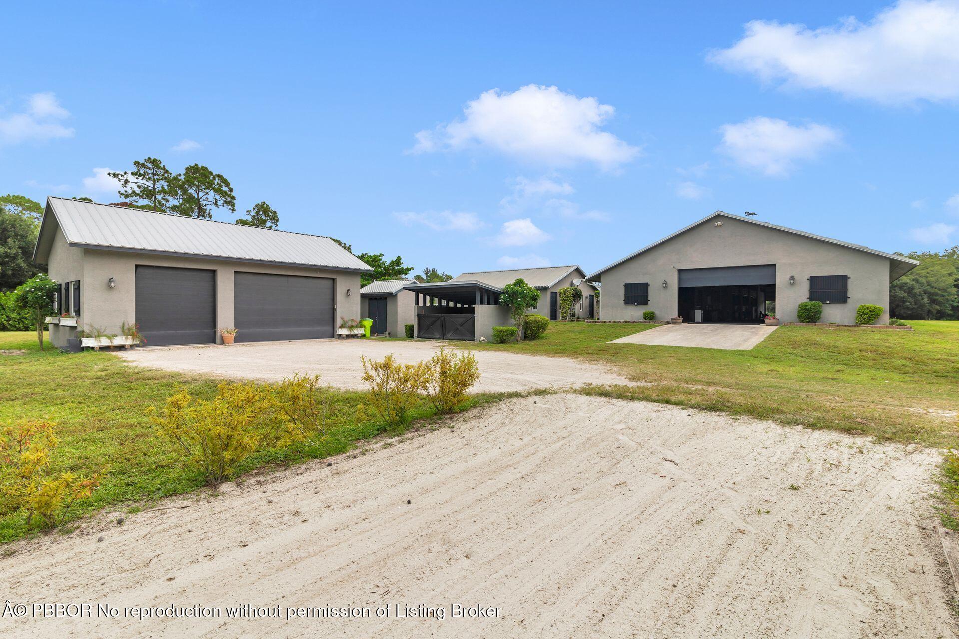 2770 E Road Loxahatchee, FL 33470 - Photo 3 of 51 a front view of a house with a garden and yard