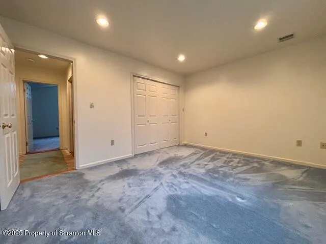 an empty room with closet and natural light
