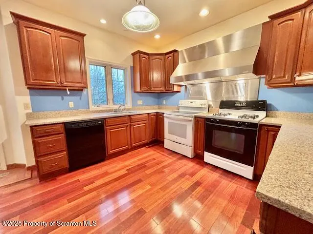 a kitchen with stainless steel appliances granite countertop a stove a sink dishwasher and a refrigerator