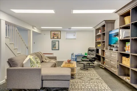 a living room with furniture a rug and a bookshelf