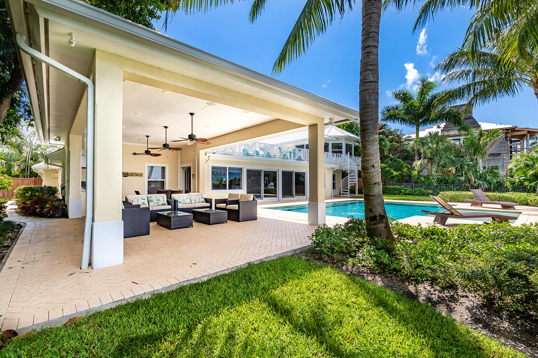 75 River Drive Tequesta, FL 33469 - Photo 17 of 42 a view of a patio with table and chairs potted plants and palm tree