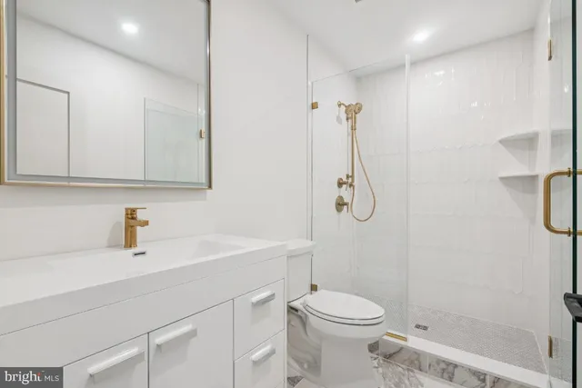 a bathroom with a sink a toilet and shower